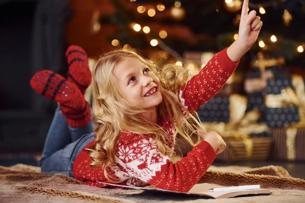 Милая Маленькая Девочка Красном Праздничном Свитере Лежит Помещении Празднует Новый — стоковое фото
