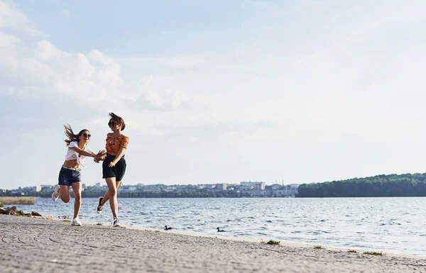 Due Amiche Corrono Divertono Spiaggia Vicino Lago Giorno Soleggiato — Foto Stock
