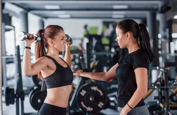 Kadın Kişisel Antrenör Spor Salonunda Egzersiz Yapan Kadına Yardım Ediyor — Stok fotoğraf