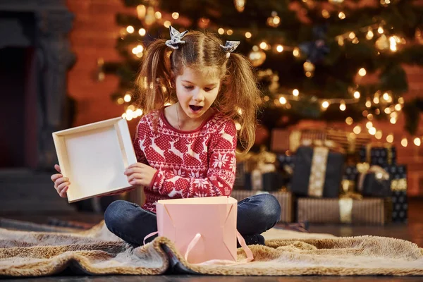 Cute Little Girl Siedzi Urządzone Christmas Room Otwarcie Pudełko Prezentów — Zdjęcie stockowe