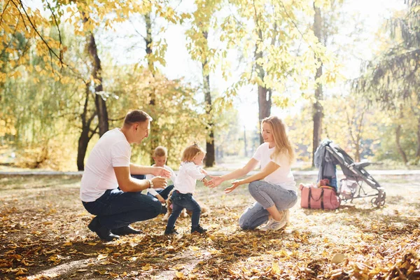 陽気若い家族は一緒に秋の公園で休息を持っています — ストック写真