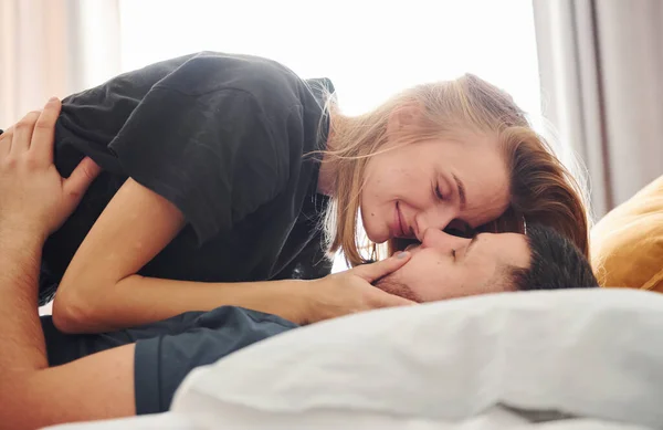 Joven Pareja Casada Besándose Dormitorio Durante Día —  Fotos de Stock