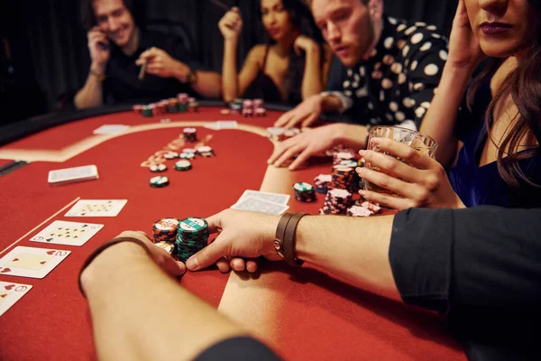 Groupe de personnes élégantes jouant ensemble au casino
