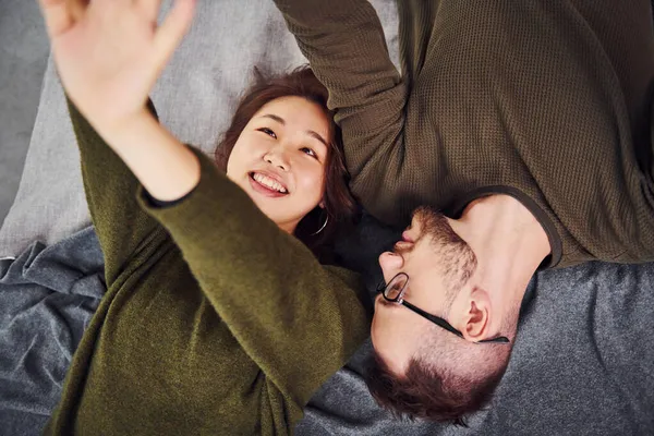 Gelukkig Multi Etnisch Koppel Casual Kleding Samen Liggend Binnen Studio — Stockfoto