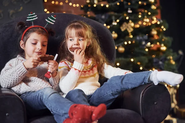 Dwie Małe Dziewczynki Siedzące Jedzące Ciasteczka Pokoju Świątecznym Urządzone — Zdjęcie stockowe
