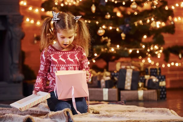 Cute Little Girl Siedzi Urządzone Christmas Room Otwarcie Pudełko Prezentów — Zdjęcie stockowe