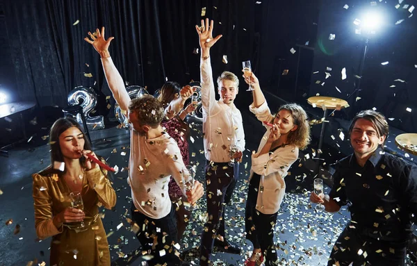 Confetti Jest Powietrzu Grupa Wesołych Przyjaciół Świętuje Nowy Rok Pomieszczeniach — Zdjęcie stockowe