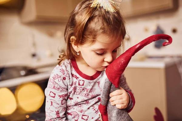 Cute Little Girl Siedzi Całuje Swoją Zabawkę Kuchni Jedzeniem — Zdjęcie stockowe