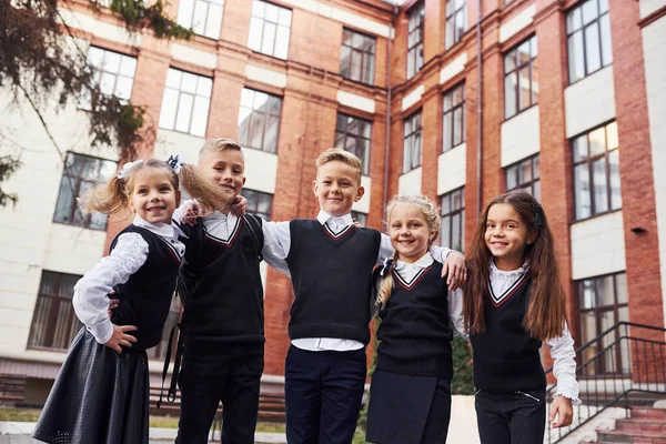 Divirtiéndose Abrazándose Grupo Niños Uniforme Escolar Que Está Aire Libre — Foto de Stock