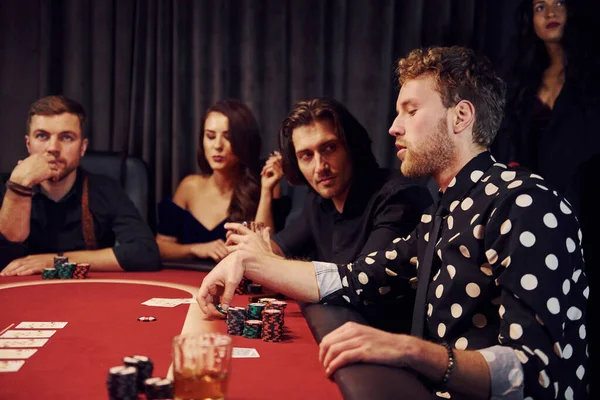 Kumarhanede poker oynayan bir grup zarif gencin yan görüntüsü..
