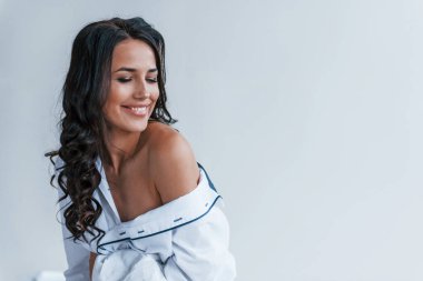 Beyaz önlüklü güzel esmer stüdyoda duruyor..