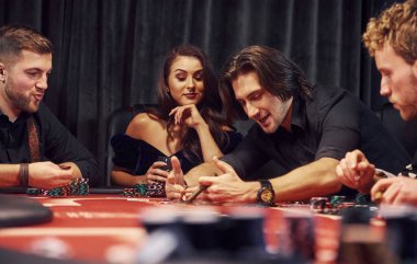 Kumarhanede birlikte poker oynayan bir grup zarif genç..