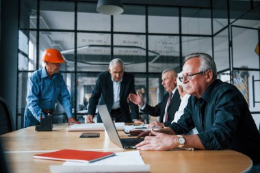 Yaşlı iş adamlarından oluşan yaşlı bir ekip ofiste bir toplantı yapıyor..