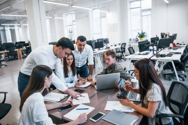 Modern ofiste birlikte çalışan genç iş adamları..