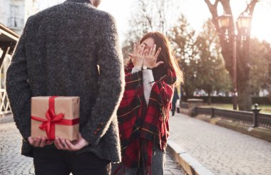 Hediye zamanı. Hediye kutusunu tutuyorum. Kafkas sevgilisiyle Asyalı bir kız..