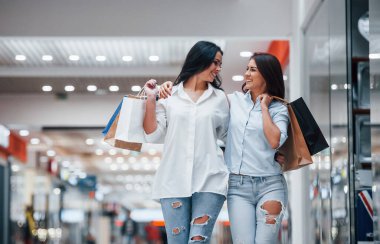 İki genç kadın süpermarkette alışveriş yapıyorlar..