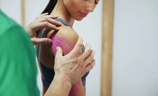 Arzt Hilft Frau Bei Schulterbehandlung Mit Kinesiotape — Stockfoto