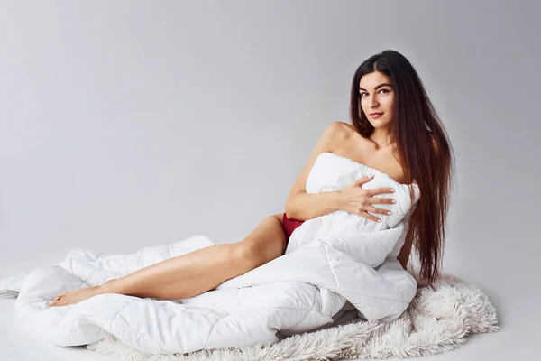 Çamaşırlı Kadın Stüdyoda Beyaz Arka Planda Oturuyor — Stok fotoğraf