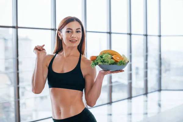 Glada Sportiga Kvinna Står Inomhus Med Hälsosam Mat Händerna — Stockfoto