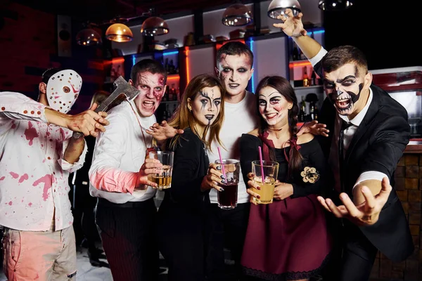 Posing for the camera. Friends is on the thematic halloween party in scary makeup and costumes.