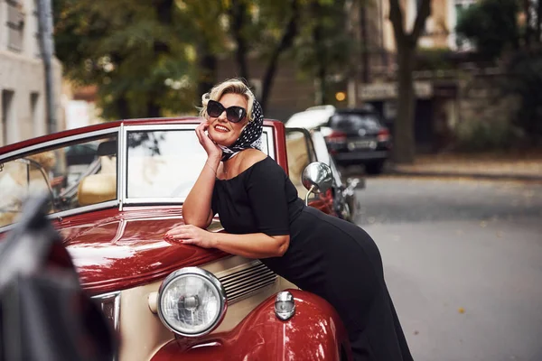 Mulher Loira Óculos Sol Vestido Preto Encostado Velho Carro Clássico — Fotografia de Stock