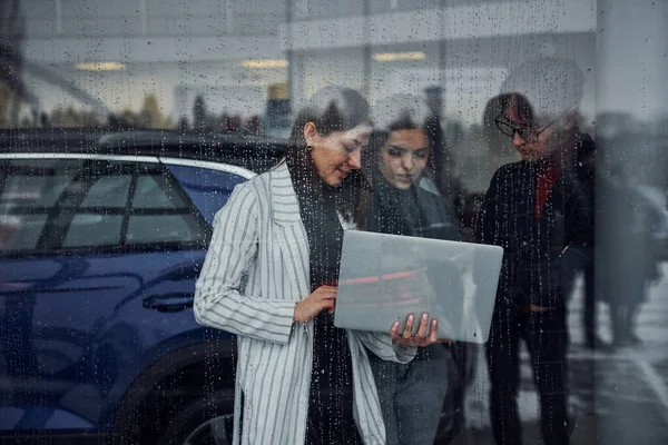 Vänner Som Står Bakom Glas Regnig Dag Flicka Håller Laptop — Stockfoto