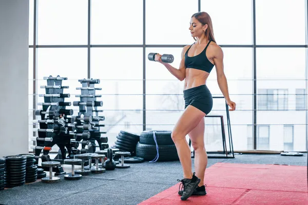 Siyah Spor Elbiseli Kadın Spor Salonunda Halterlerle Egzersiz Yapıyor — Stok fotoğraf