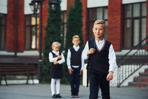 Groupe Enfants Uniforme Scolaire Posant Caméra Extérieur Ensemble Près Bâtiment — Photo