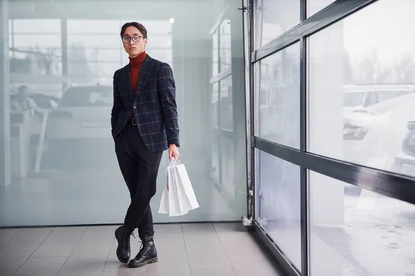 Alışveriş Torbalarıyla Lüks Takım Elbiseli Genç Adamı Resmi Kıyafetler Ofiste — Stok fotoğraf