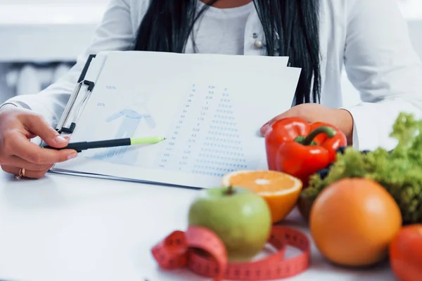 Female Nutritionist White Coat Sitting Indoors Office Workplace Showing Information — Stockfoto
