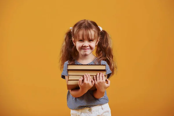 Χαριτωμένο Κοριτσάκι Βιβλίο Στα Χέρια Στο Στούντιο Κίτρινο Φόντο — Φωτογραφία Αρχείου
