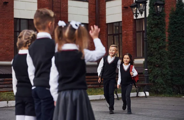 有一个会议 一群穿着校服的孩子在教育大楼附近一起外出 — 图库照片