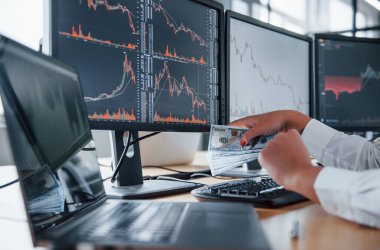 Monitörlerin yanında para tutan kadınların el görüntülerini kapat..