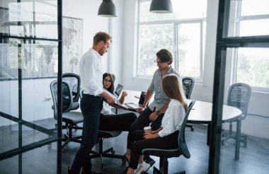 Aktif konuşma. Ofiste çalışan resmi kıyafetli genç iş adamları..