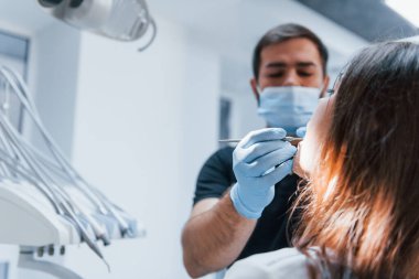 Genç yetişkin bir kadın dişçi kliniğine gidiyor. Stomatoloji kavramı.