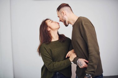 Gündelik giysiler içindeki mutlu çoklu etnik çift stüdyoda birlikte. Asyalı kız arkadaşı olan beyaz bir adam..