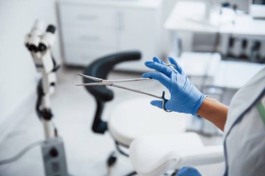 Forseps tutan kadın doktor ellerine yakından bakın..
