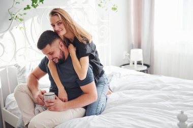 Bir bardak içki. Genç evli çiftler gündüzleri yatak odasında vakit geçirirler..