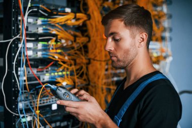 Üniformalı genç adamın sunucu odasında internet teçhizatı ve dinleme cihazlarıyla ilgili bir işi var..