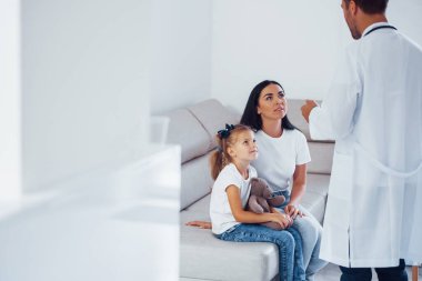 Anne ve tatlı kızı kliniği ziyaret ediyor. Doktoru dinliyorum..