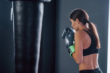 Spor kıyafetli genç bir kadın spor salonunda egzersiz yapıyor. Boks kavramı.