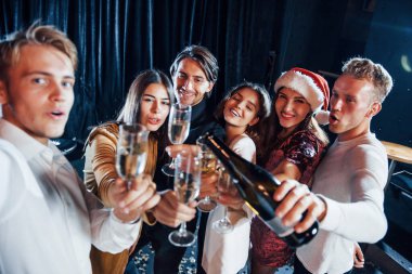 Selfie çekiyor. Bir grup neşeli arkadaş yeni yılı evde ellerinde içkilerle kutluyorlar..