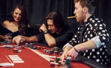 Kumarhanede birlikte poker oynayan bir grup zarif genç..