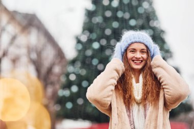 Kalın elbiseli genç kız şehirde yürüyüşe çıktı..