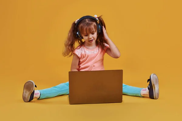 Cute Little Girl Laptop Headphones Studio Yellow Background — Stock Photo, Image