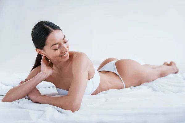 Mulher Sorrindo Positivo Roupa Interior Deitado Estúdio Contra Fundo Branco — Fotografia de Stock