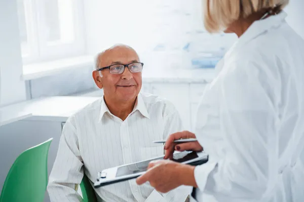 Senior Man Hebben Overleg Kliniek Door Vrouwelijke Arts — Stockfoto