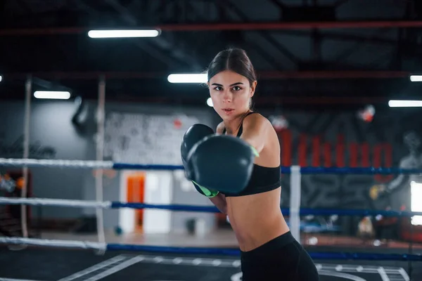 stock image Young woman in sportive wear is in the boxing ring having exercise day.