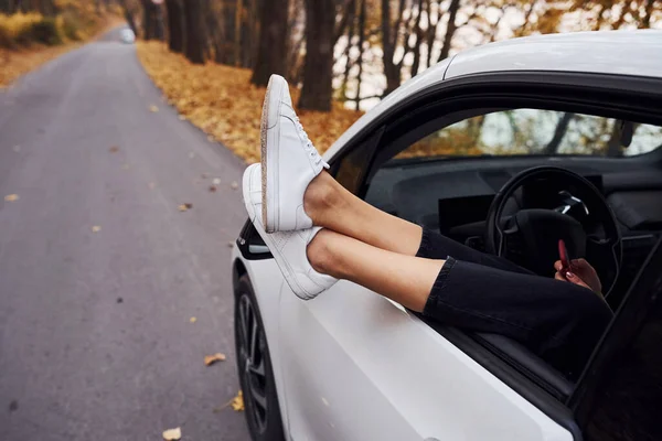 Die Beine Der Frau Sind Aus Dem Autofenster Modernes Nagelneues — Stockfoto