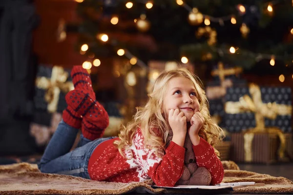 かわいいです女の子で赤お祝いセーター横にダウンとともにテディベア屋内お祝い新年 — ストック写真
